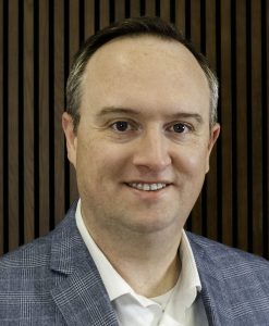 Professional headshot of Mike Naughton in blazer