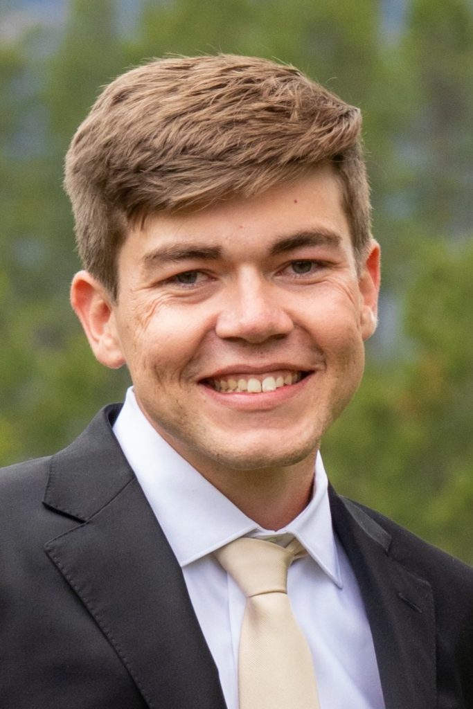 Professional headshot of Dr. Thomas Gifford, 2026 Utility Policy Fellow and environmental economist, smiling and looking toward the camera in an outdoor setting.