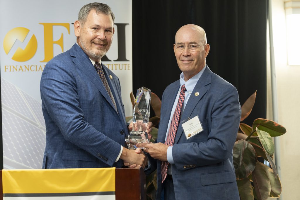 FRI Executive Director Mike Sykuta (left) presenting the 2026 Crystal Award for Distinguished Contribution to Greg White, retired executive director of the National Association of Regulatory Utility Commissioners (NARUC) and former commissioner on the Michigan Public Service Commission